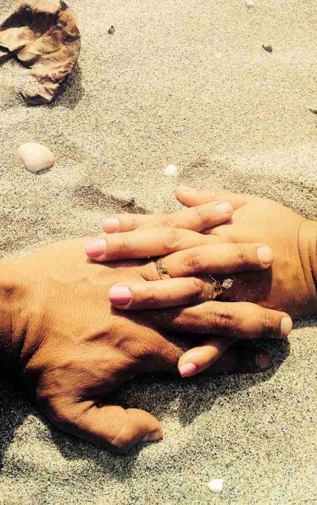 interior de artículo, pareja con mano agarrada en la playa