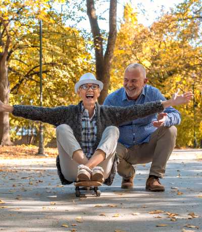 Dos personas mayores disfrutando al aire libre, representando actividades para personas con párkinson